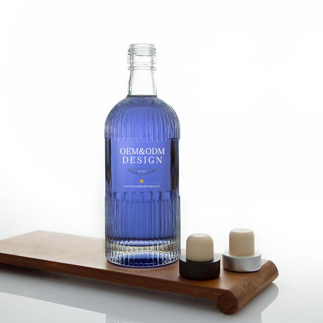 Botella de licor de vidrio rayado redondo con acabado de tornillo