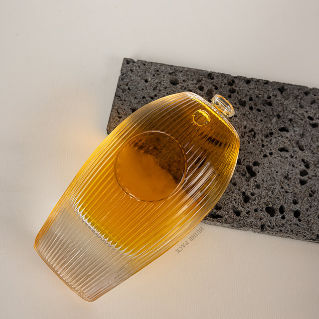 Botella de licor de vidrio ovalado verticalmente con buque de vidrio