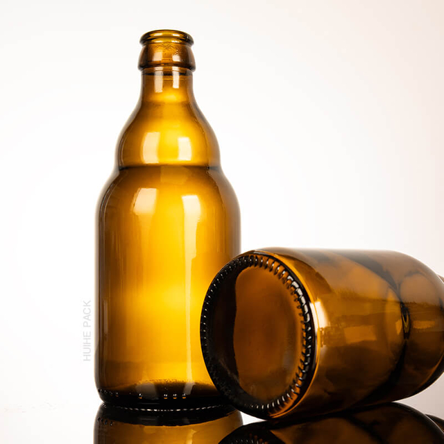 En stock Botella de cerveza de vidrio vacío con tapa de la corona