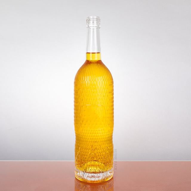 Botella de vodka de vidrio transparente de cilindro de textura con forma de guijarro