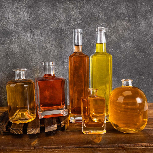 En botellas de vidrio de licor redonda transparente transparente almacenado