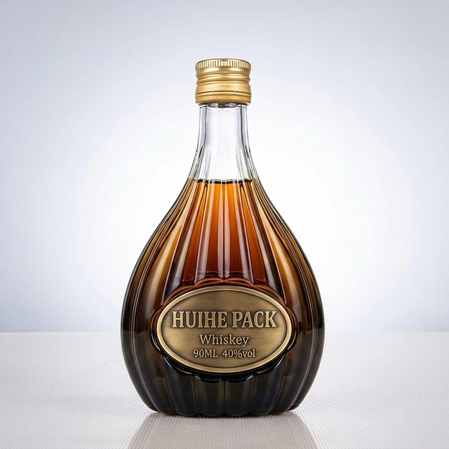 Botella de licor de vidrio en forma de pera con patrones de acanalado vertical