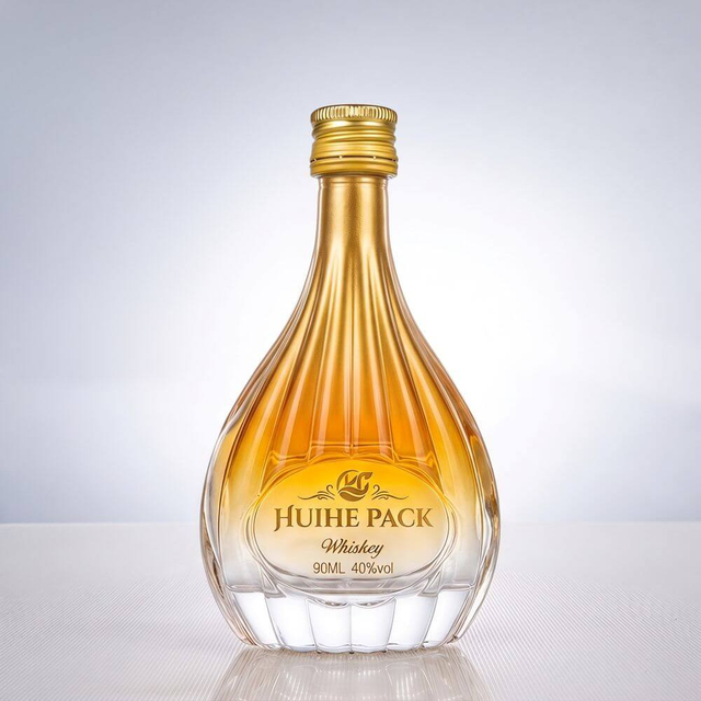 Botella de licor de vidrio en forma de pera con patrones de acanalado vertical